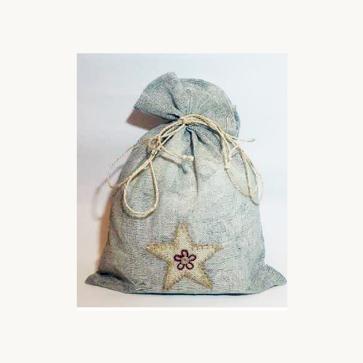 Sacchetto in juta grigio perla con decorazione a stella in cotone ricamata a mano, realizzato da CORR in Bangladesh – packaging equosolidale