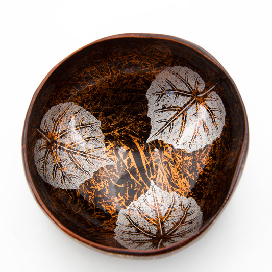 particolare della ciotola in cocco con decorazione fatta a mano di foglie color rame